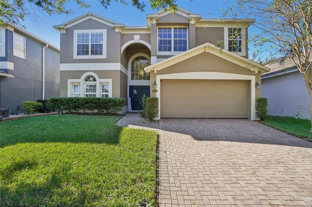 view of front of house with cooling unit, a garage, and a front lawn