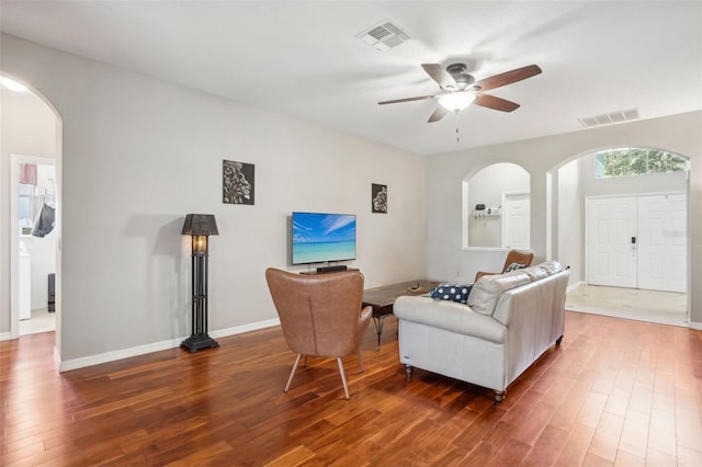 living room with ceiling fan and dark hardwood / wood-style flooring