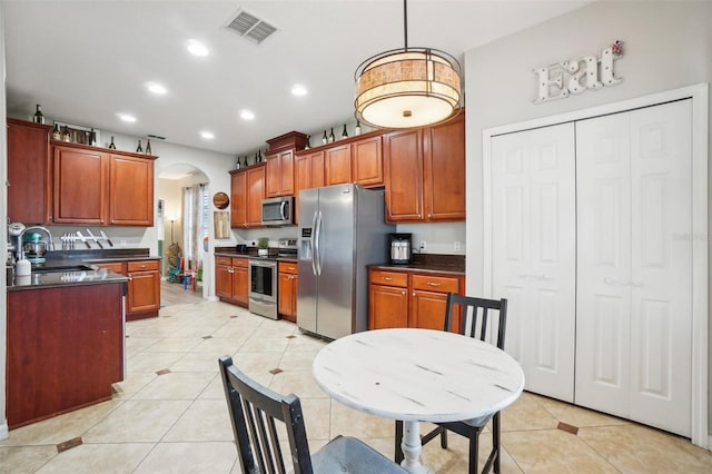 kitchen with pendant lighting, light tile patterned flooring, sink, and appliances with stainless steel finishes