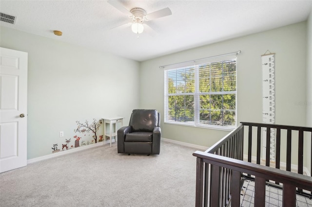 carpeted bedroom with ceiling fan and a nursery area