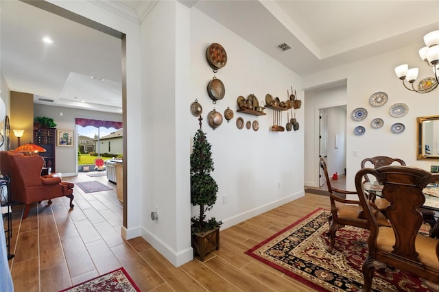 dining area featuring a raised ceiling, a chandelier, and hardwood / wood-style flooring