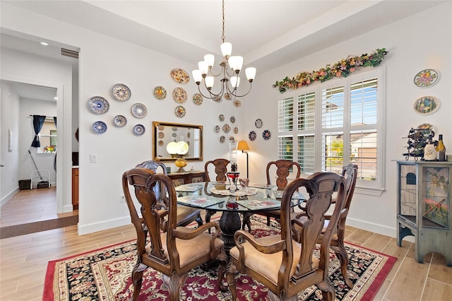 dining area with an inviting chandelier and light hardwood / wood-style flooring