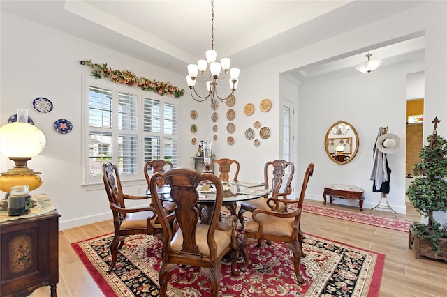 dining space featuring light hardwood / wood-style flooring and a notable chandelier