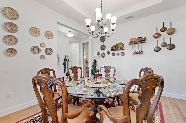 dining area featuring a notable chandelier and light wood-type flooring