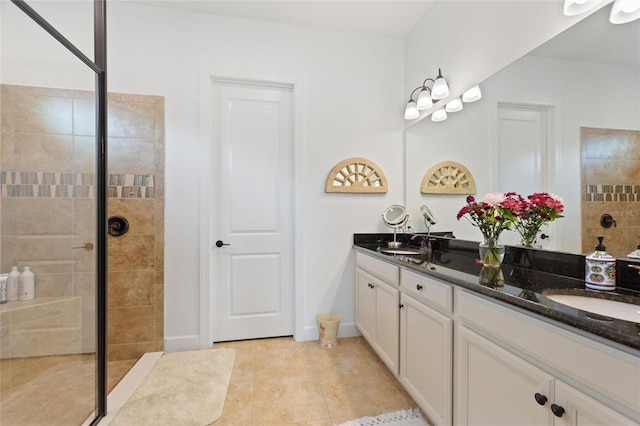 bathroom with tiled shower, vanity, and tile patterned floors