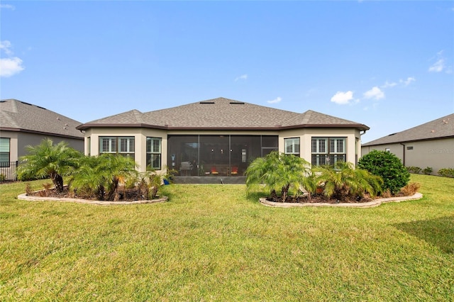 back of house featuring a sunroom and a lawn