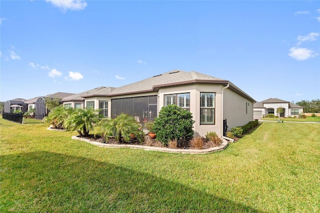 view of side of property with a sunroom and a lawn