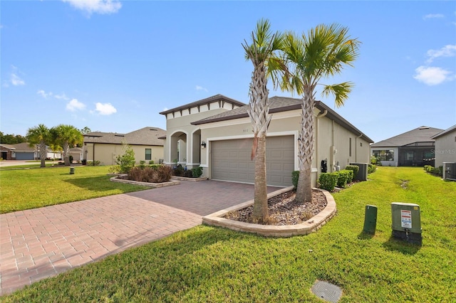 view of front of home featuring a front lawn, central AC unit, and a garage