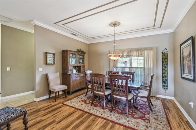 dining room with wood-type flooring and crown molding