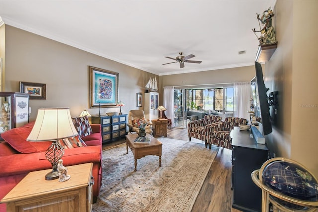 living room featuring crown molding, ceiling fan, and dark wood-type flooring