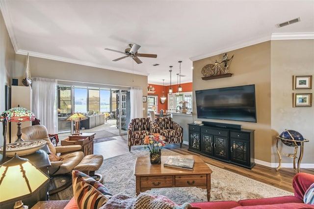 living room featuring hardwood / wood-style flooring, ceiling fan, and crown molding