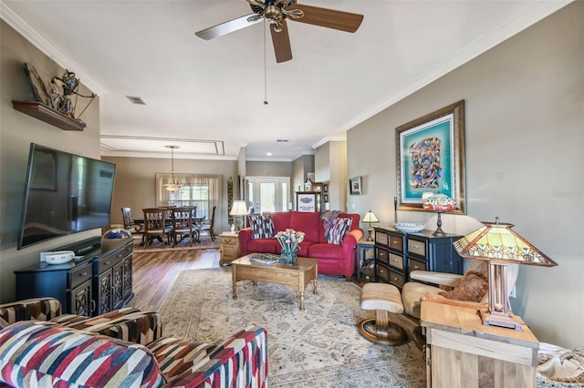 living room with hardwood / wood-style floors, ceiling fan, and ornamental molding