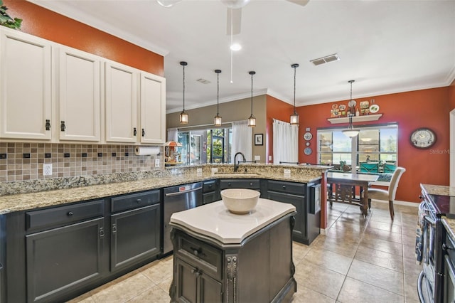 kitchen with white cabinets, appliances with stainless steel finishes, a center island, and hanging light fixtures