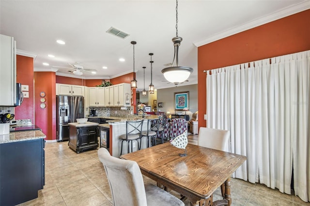 dining space featuring light tile patterned floors, ceiling fan, and crown molding