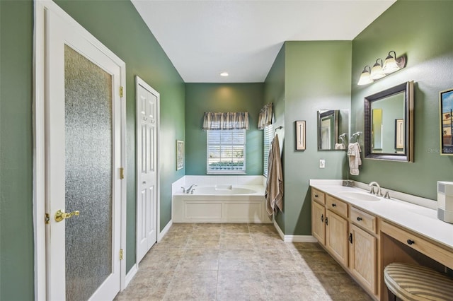 bathroom with tile patterned flooring, a bathtub, and vanity