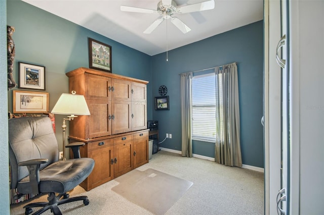 carpeted home office featuring ceiling fan