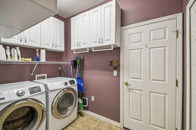 laundry room with cabinets, light tile patterned floors, and washer and dryer