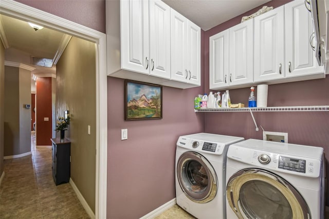 clothes washing area featuring cabinets and separate washer and dryer