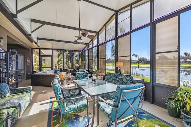 sunroom featuring ceiling fan, a water view, and lofted ceiling