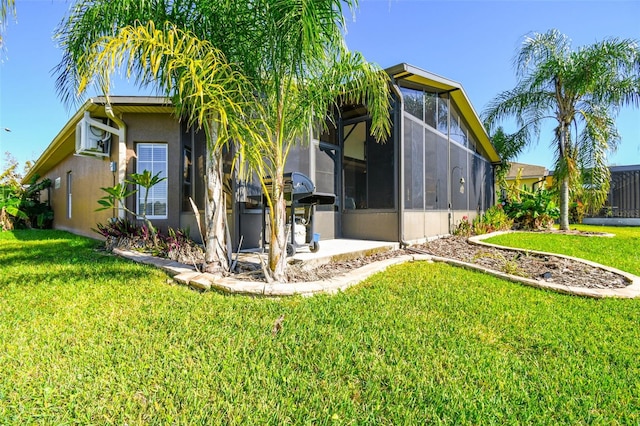 back of house with a lanai, a patio area, a yard, and a wall mounted air conditioner