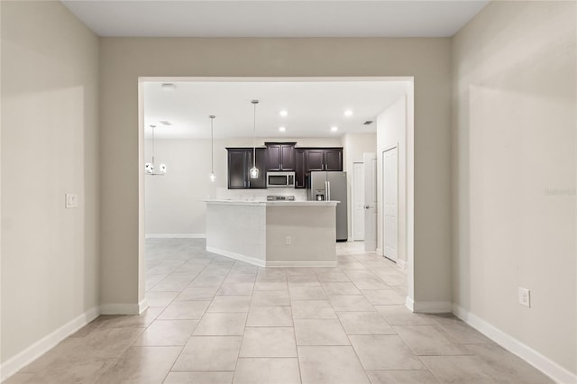 kitchen with a center island, decorative light fixtures, light tile patterned floors, appliances with stainless steel finishes, and a notable chandelier