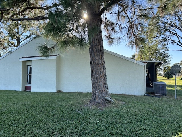 view of side of home featuring a lawn and central air condition unit