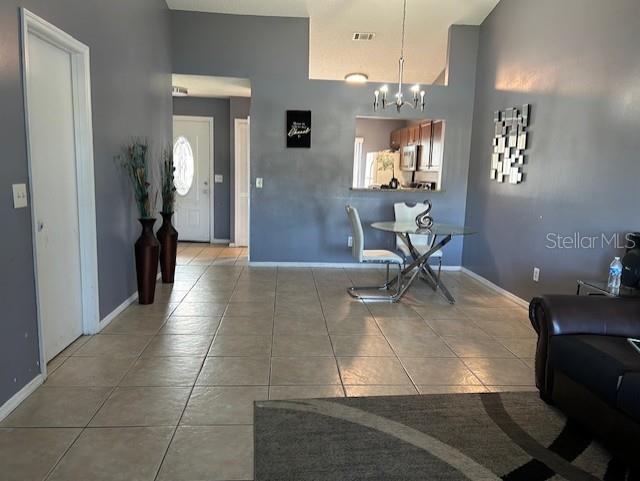 dining area with tile patterned floors, a wealth of natural light, and a chandelier