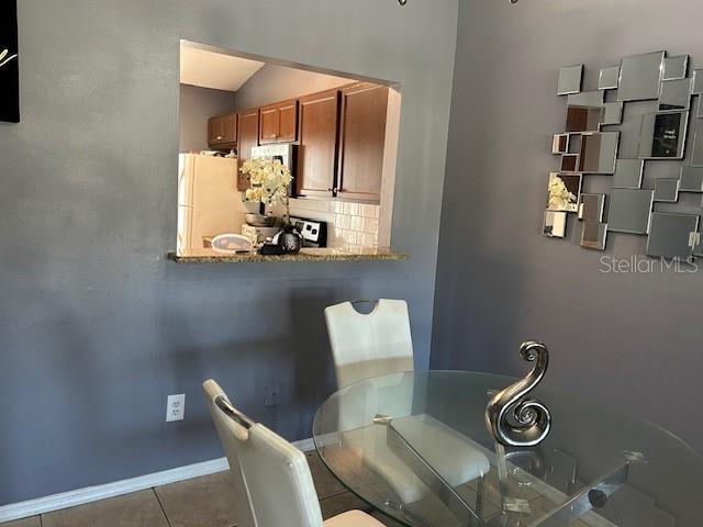 tiled dining area with lofted ceiling