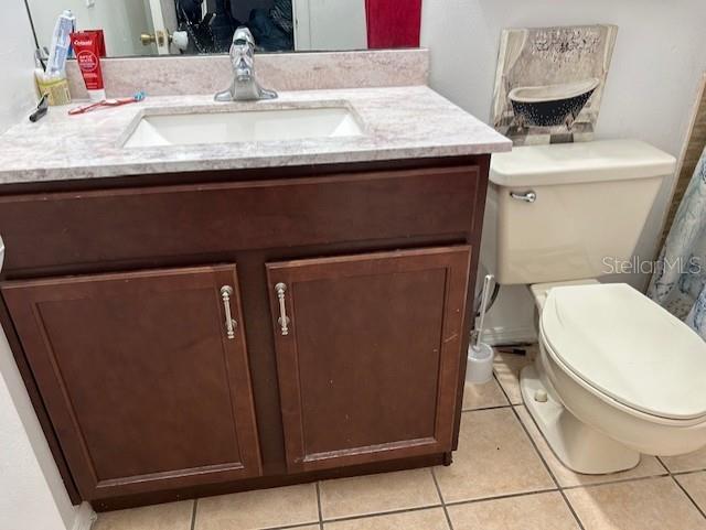 bathroom featuring tile patterned flooring, vanity, and toilet