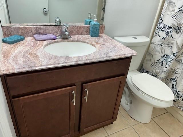 bathroom featuring tile patterned flooring, vanity, and toilet