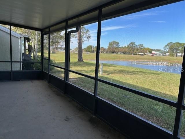 unfurnished sunroom featuring a water view