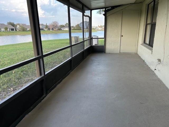 unfurnished sunroom with a water view