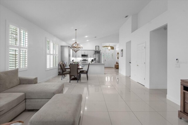 living room with light tile patterned flooring, lofted ceiling, a wealth of natural light, and a chandelier