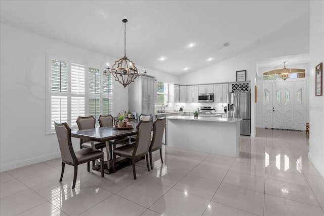 tiled dining room featuring sink, lofted ceiling, and a notable chandelier