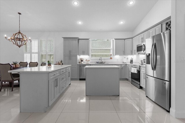 kitchen with a center island, a healthy amount of sunlight, appliances with stainless steel finishes, and vaulted ceiling