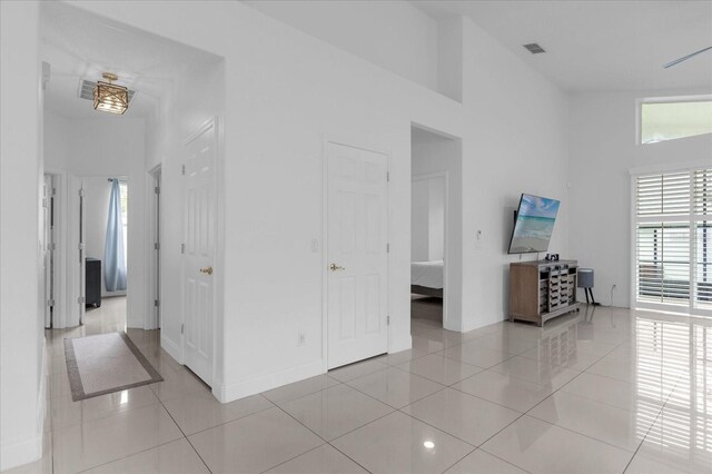 interior space with high vaulted ceiling and light tile patterned flooring