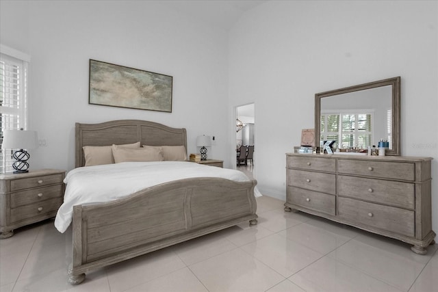 tiled bedroom featuring a towering ceiling