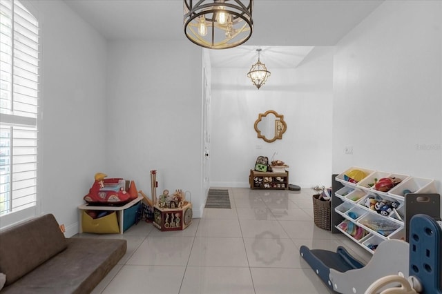 tiled entryway featuring a notable chandelier