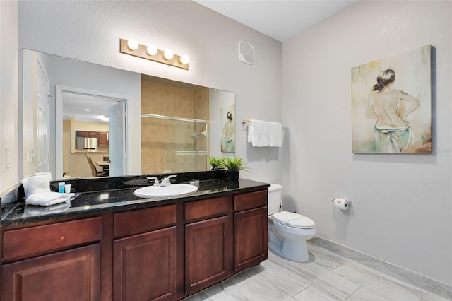 bathroom featuring toilet, an enclosed shower, and vanity