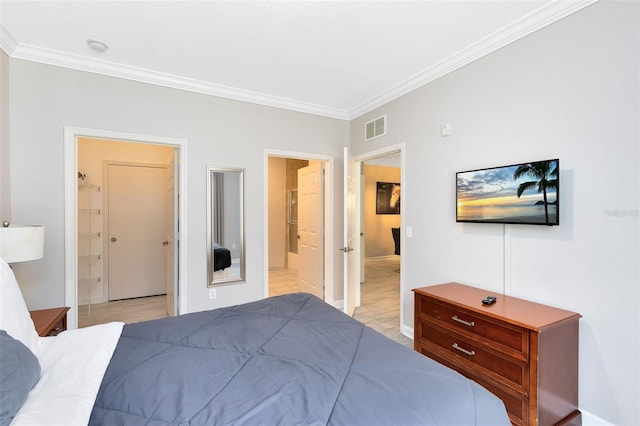 bedroom with a closet, a walk in closet, crown molding, and ensuite bath