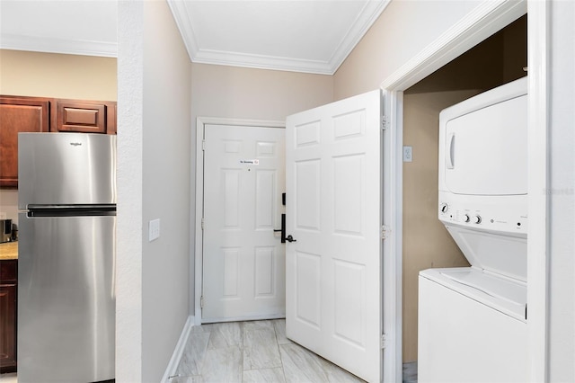 clothes washing area featuring stacked washer / dryer and ornamental molding