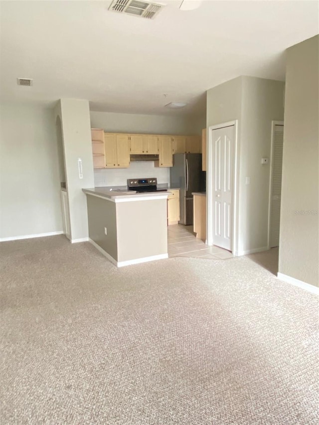 kitchen featuring kitchen peninsula, stainless steel appliances, light brown cabinetry, and light carpet