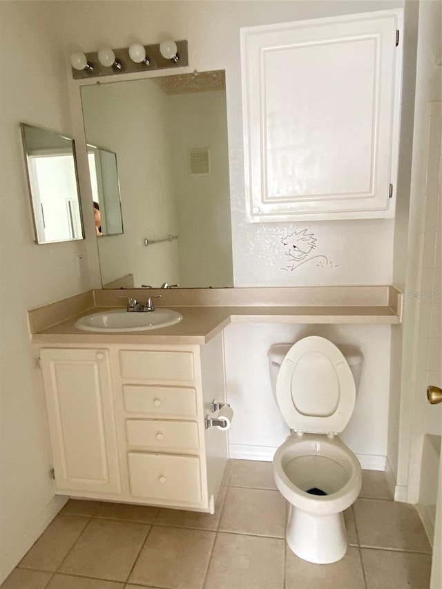 bathroom featuring tile patterned floors, a bathtub, vanity, and toilet