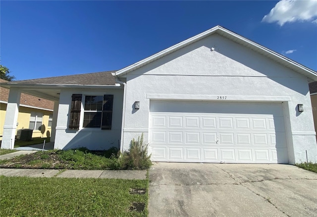 ranch-style home with a garage and central AC unit