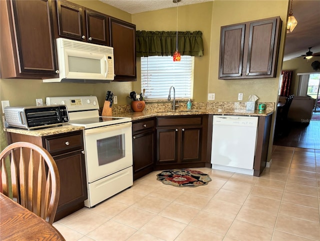 kitchen featuring white appliances, light tile patterned flooring, light stone countertops, pendant lighting, and sink