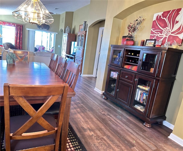 dining area with an inviting chandelier and dark hardwood / wood-style flooring