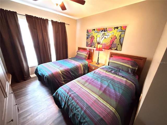 bedroom featuring ceiling fan, hardwood / wood-style flooring, and multiple windows