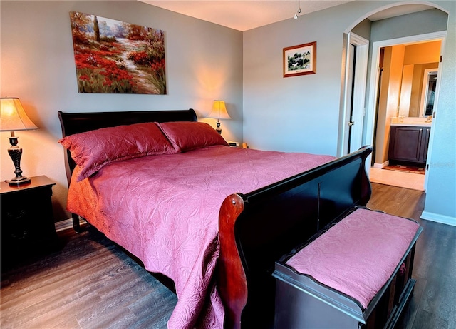 bedroom featuring connected bathroom and hardwood / wood-style floors