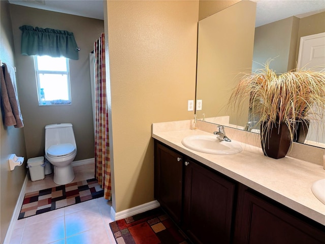 bathroom with toilet, vanity, and tile patterned flooring