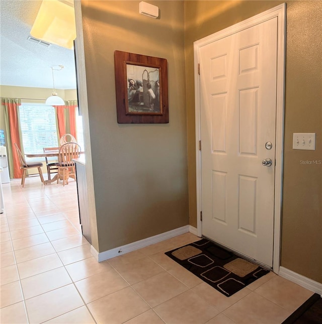 foyer featuring light tile patterned floors and a textured ceiling